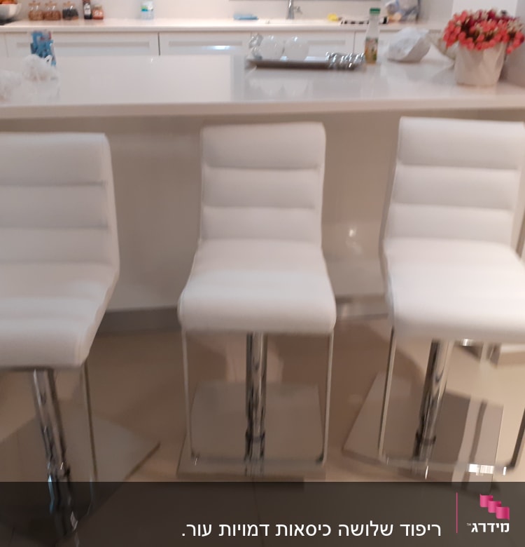 שלושה כיסאות מרופדים בלבן עם בסיס מתכת